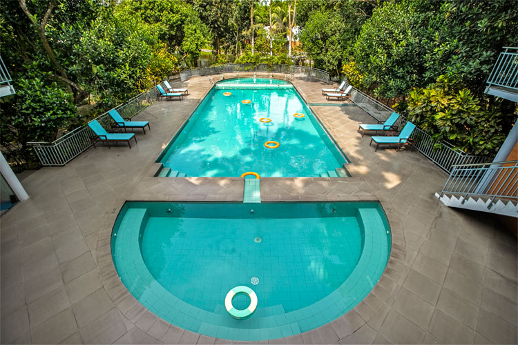 Outdoor swimming pool surrounded by trees at Dream Square Resort